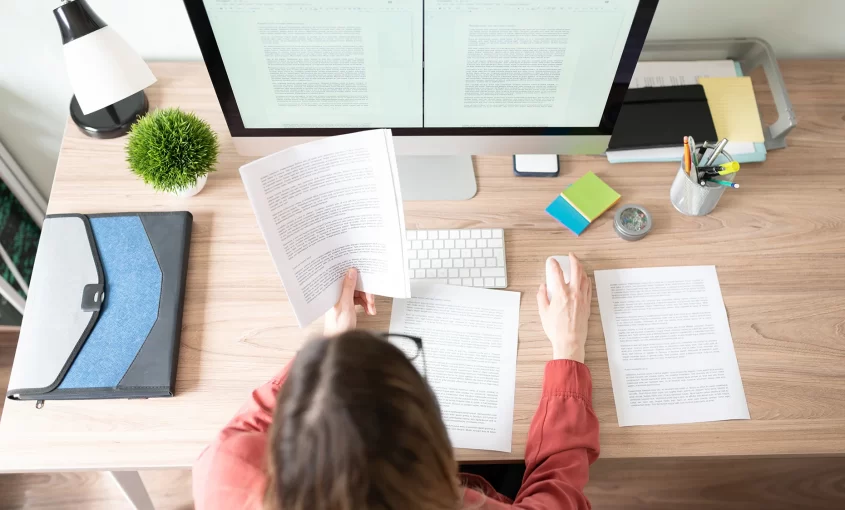 Top view of the workspace of a female translator working on a document translation